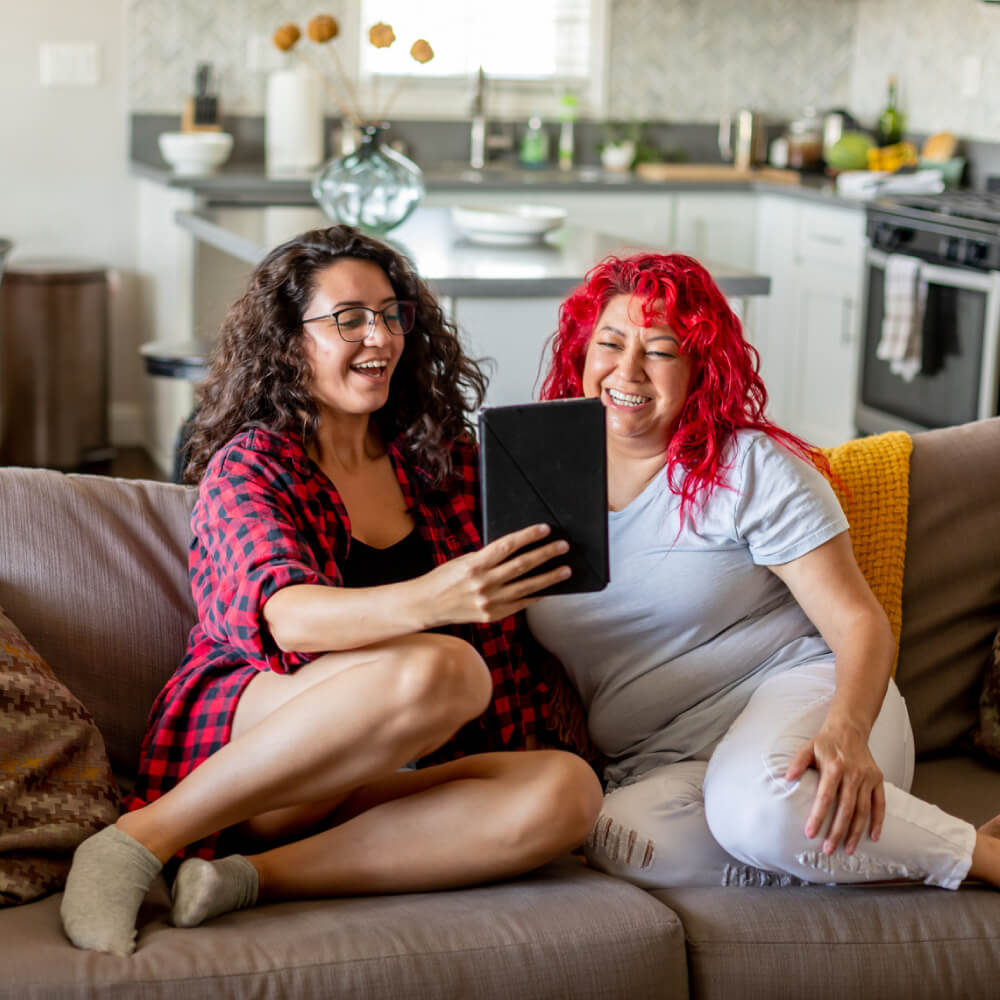 two women laughing at an iPad (mobile)